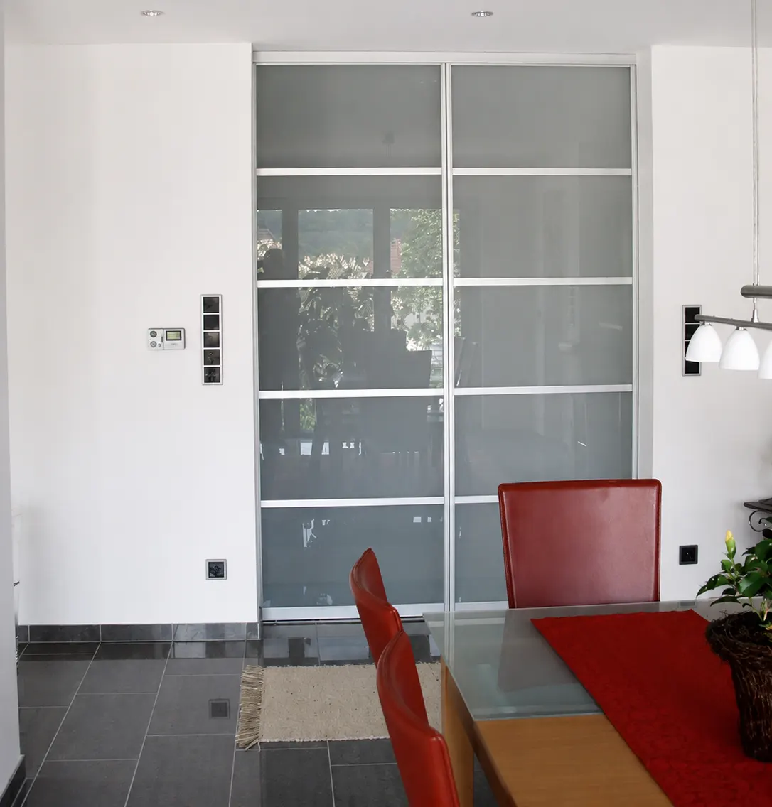Geöffnete Tür, Blick in ein lichtdurchflutetes Architekturbüro mit Zeichentisch und Regalen